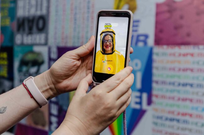 Legend: Minister Luciana Santos of the Ministry of Science, Technology and Innovation (MCTI) interacts with CNPEM's Instagram profile, virtually trying on the protective suit for level 4 biosafety containment labs (Photo credit: Ministry of Science, Technology and Innovation/Outreach)