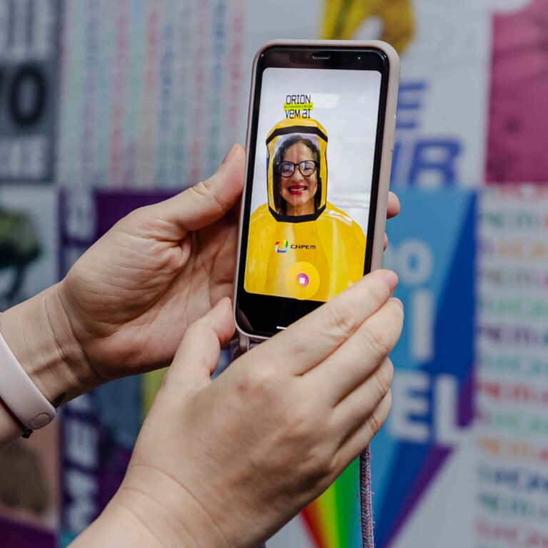 snct_red Legend: Minister Luciana Santos of the Ministry of Science, Technology and Innovation (MCTI) interacts with CNPEM's Instagram profile, virtually trying on the protective suit for level 4 biosafety containment labs (Photo credit: Ministry of Science, Technology and Innovation/Outreach)