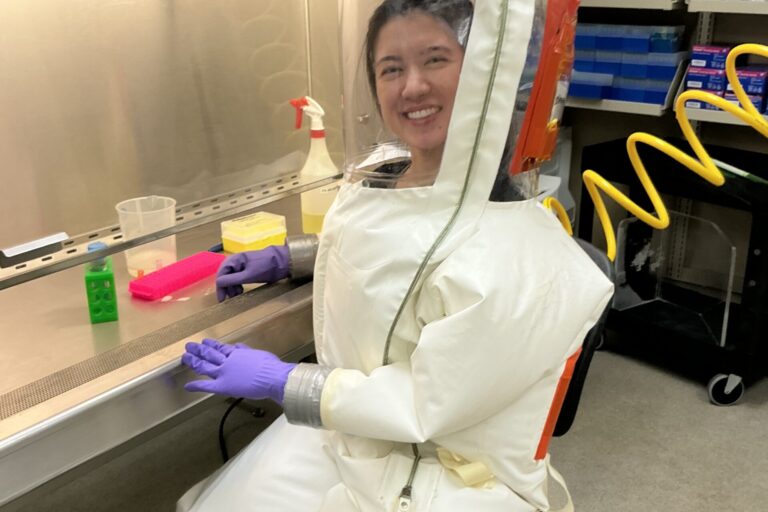 Na foto, pesquisadora Jacqueline Shimizu do CNPEM em laboratório de treinamento NB4 na UTMB, trajando o macacão típico de operação nesses ambientes (Créditos: Divulgação/CNPEM)